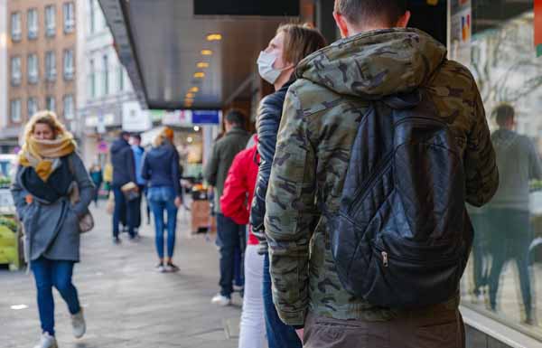Selected focus, European people queue and wait on sidewalk outsi