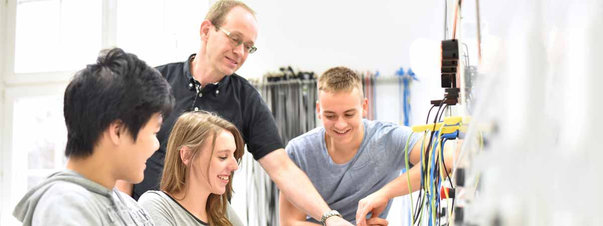 technische Berufsausbildung - Ausbilder mit jugendlichen Azubis im Unterricht an der Berufsschule // trainers with young apprentices